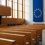 Sentencia del TJUE sobre la amnistía: ¿cuándo puede volver Puigdemont a España? 1 Sala del Tribunal de Justicia de la Unión Europea con la bandera de la UE y una balanza de la justicia